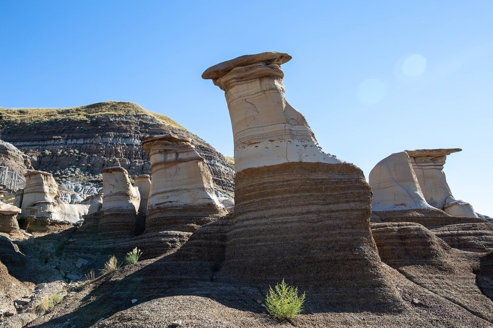Capped hoodoo rock formations rising from the striped badlands near Drumheller, Alberta